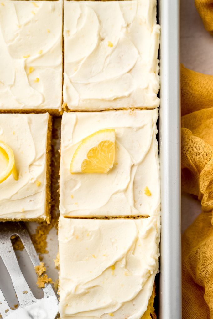 Aerial photo of a lemon sheet cake sliced and sitting in a baking pan.