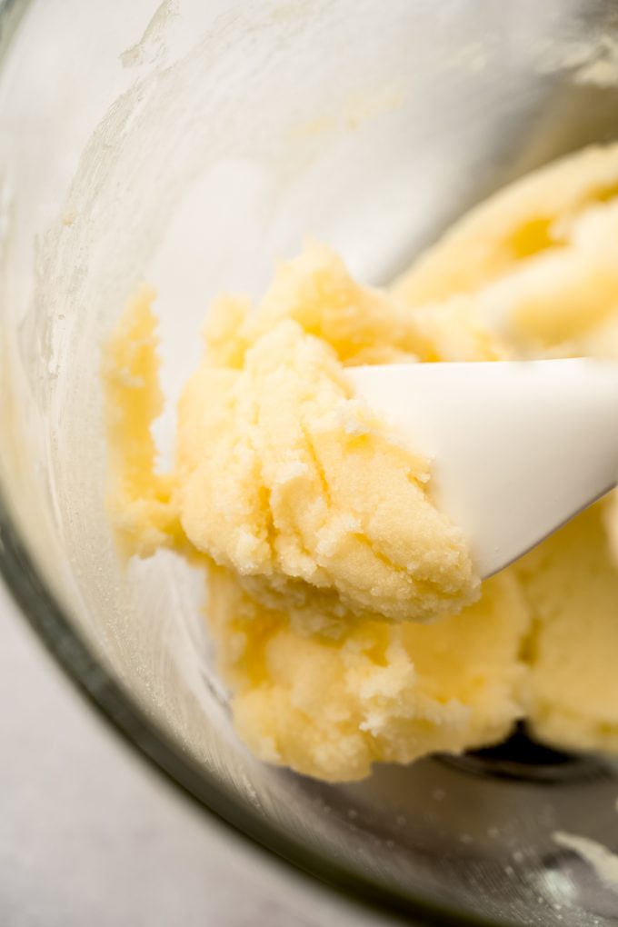 A spatula with creamed butter and sugar with lemon zest on it.