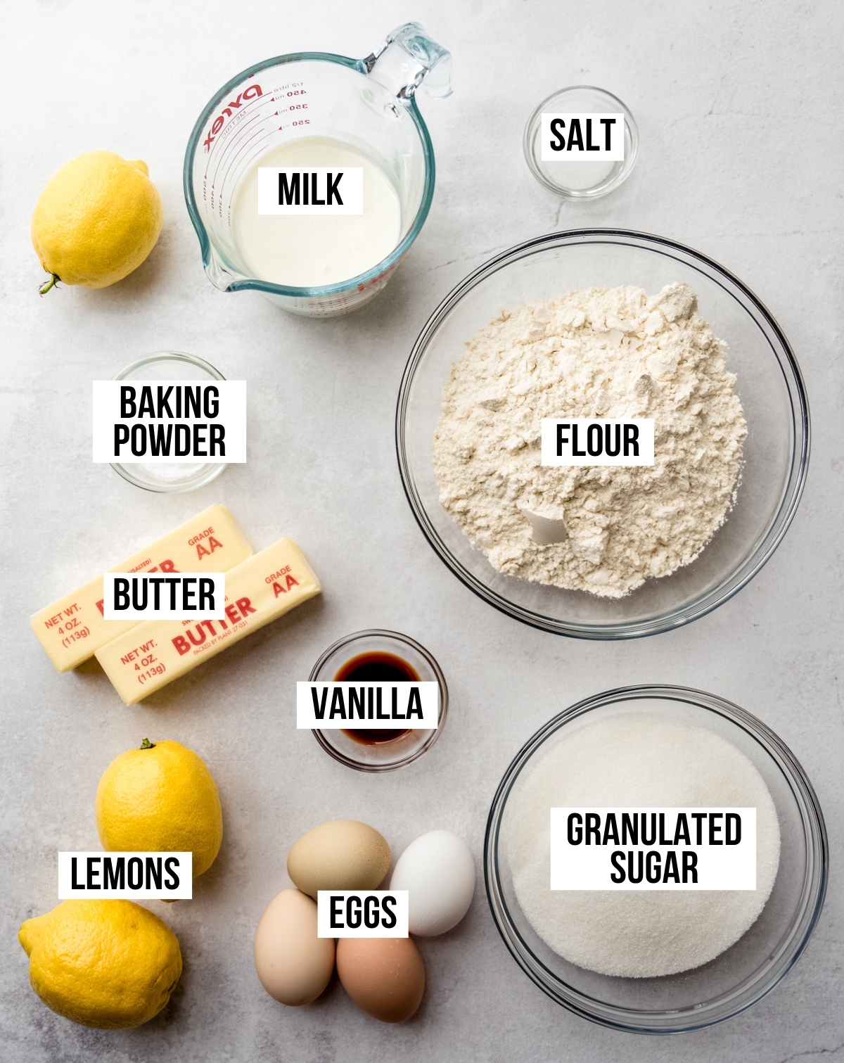 Aerial photo of the ingredients to make lemon sheet cake with text overlay labeling each ingredient.