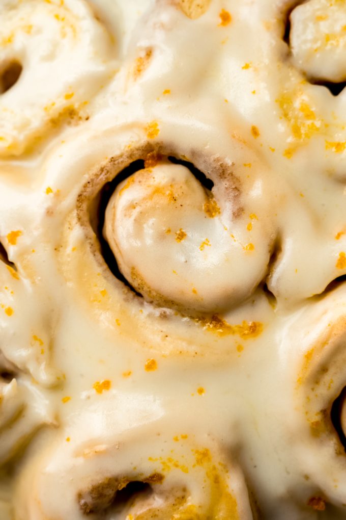 Aerial closeup photo of orange cinnamon rolls in a baking dish.