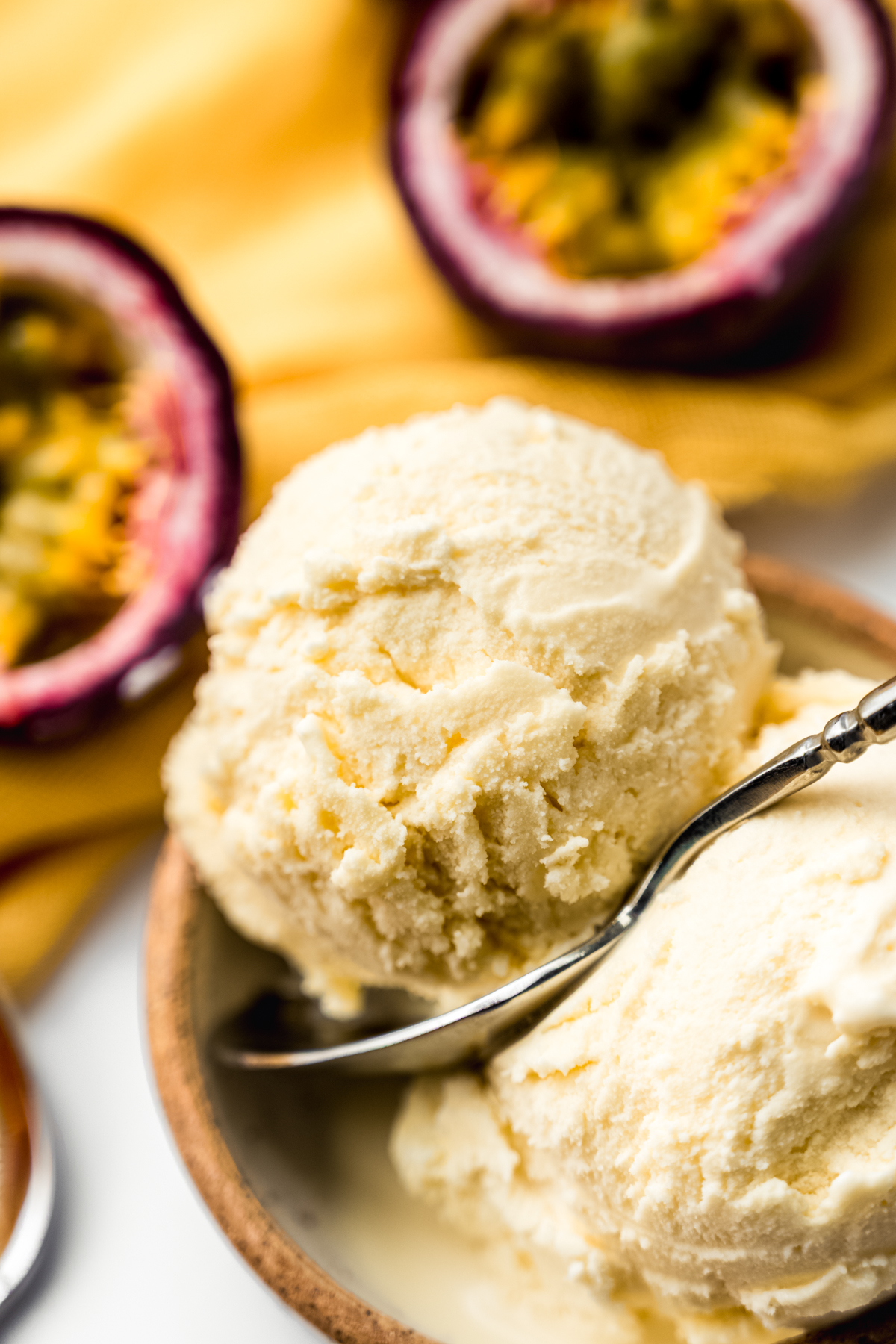 Passion fruit ice cream in a bowl with a spoon.