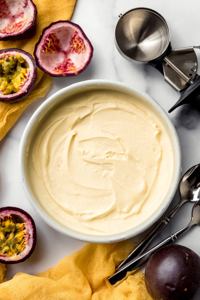 Aerial photo of passion fruit ice cream in a round container.