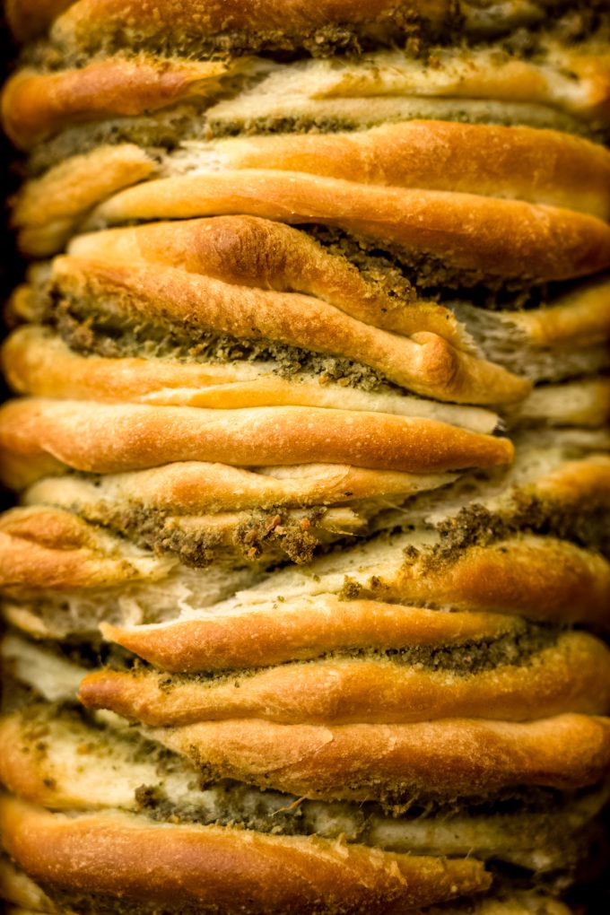 Aerial photo of pesto pull-apart bread in a baking pan.