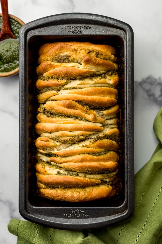 Aerial photo of pesto pull-apart bread in a baking pan.