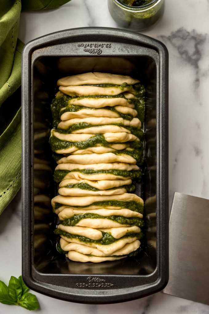 Aerial photo of an unbaked loaf of pesto pull-apart bread.