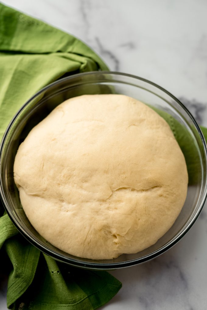 A loaf of yeasted dough in a bowl after rising.