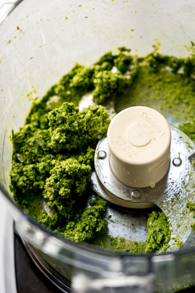 Homemade pesto being made in a food processor.