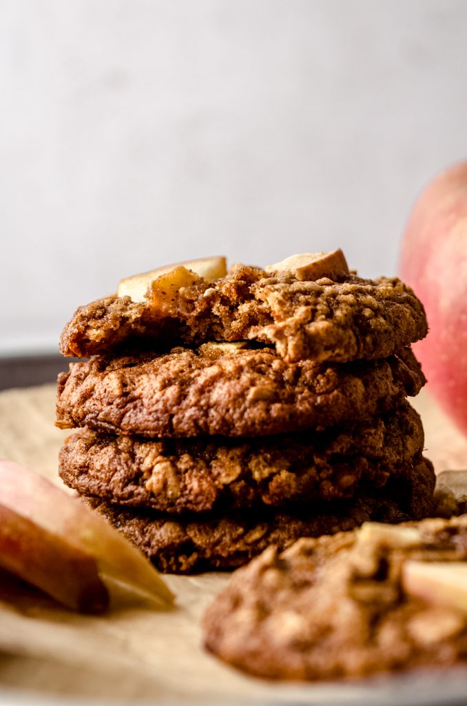 A stack of apple oatmeal cookies with a bite taken out of the one on top.