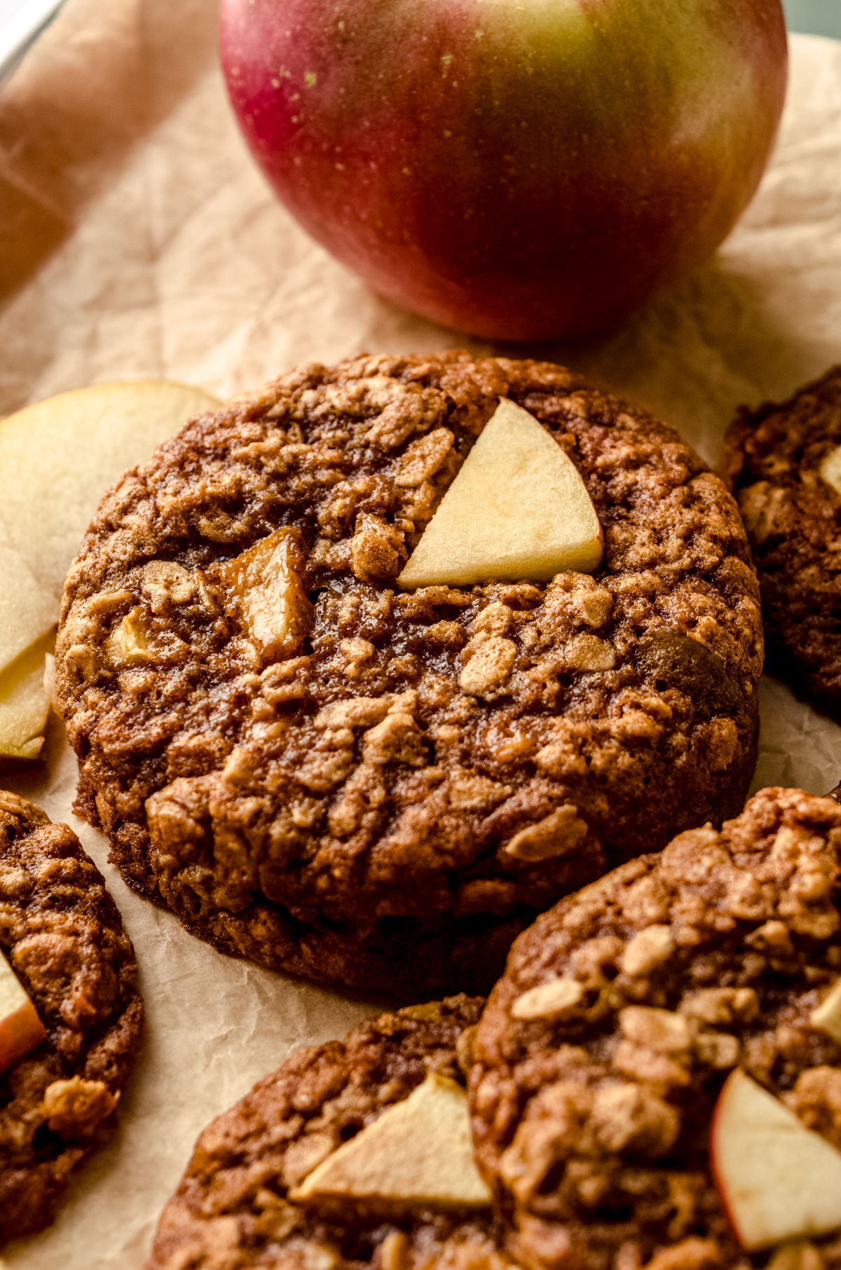 Apple oatmeal cookies on a surface with an apple in the background.