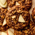 Aerial photo of apple oatmeal cookies on a surface with slices of apples around the cookies.