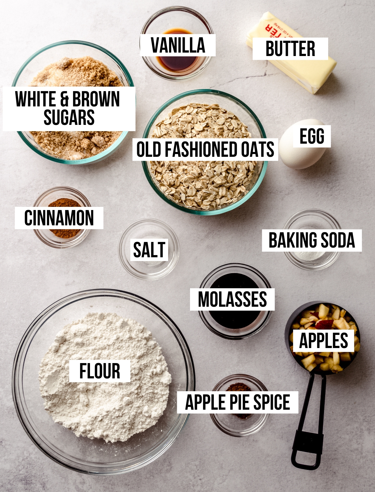 Aerial photo of ingredients to make apple oatmeal cookies with text overlay labeling each ingredient.