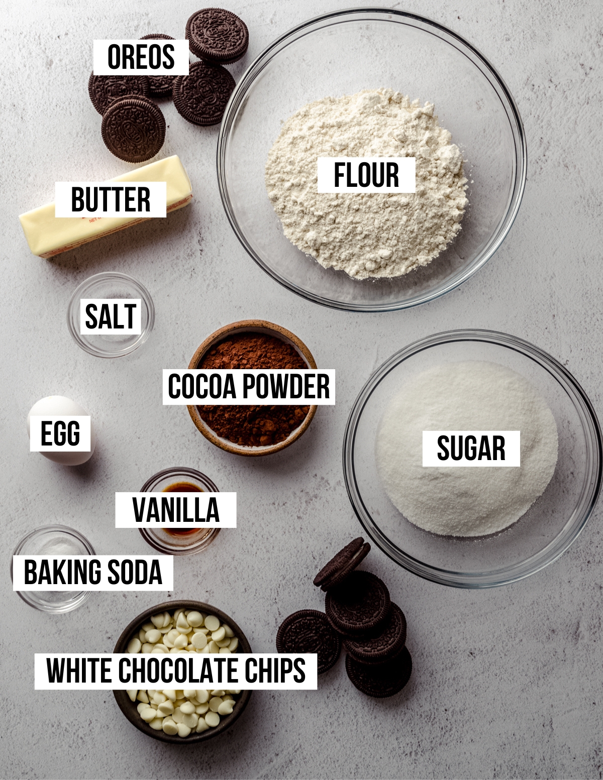 Aerial photo of ingredients to make chocolate cookies and cream cookies with text overlay labeling each ingredient.