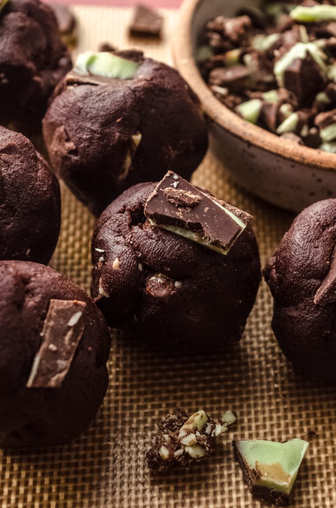 Balls of chocolate mint cookie dough on a baking sheet.