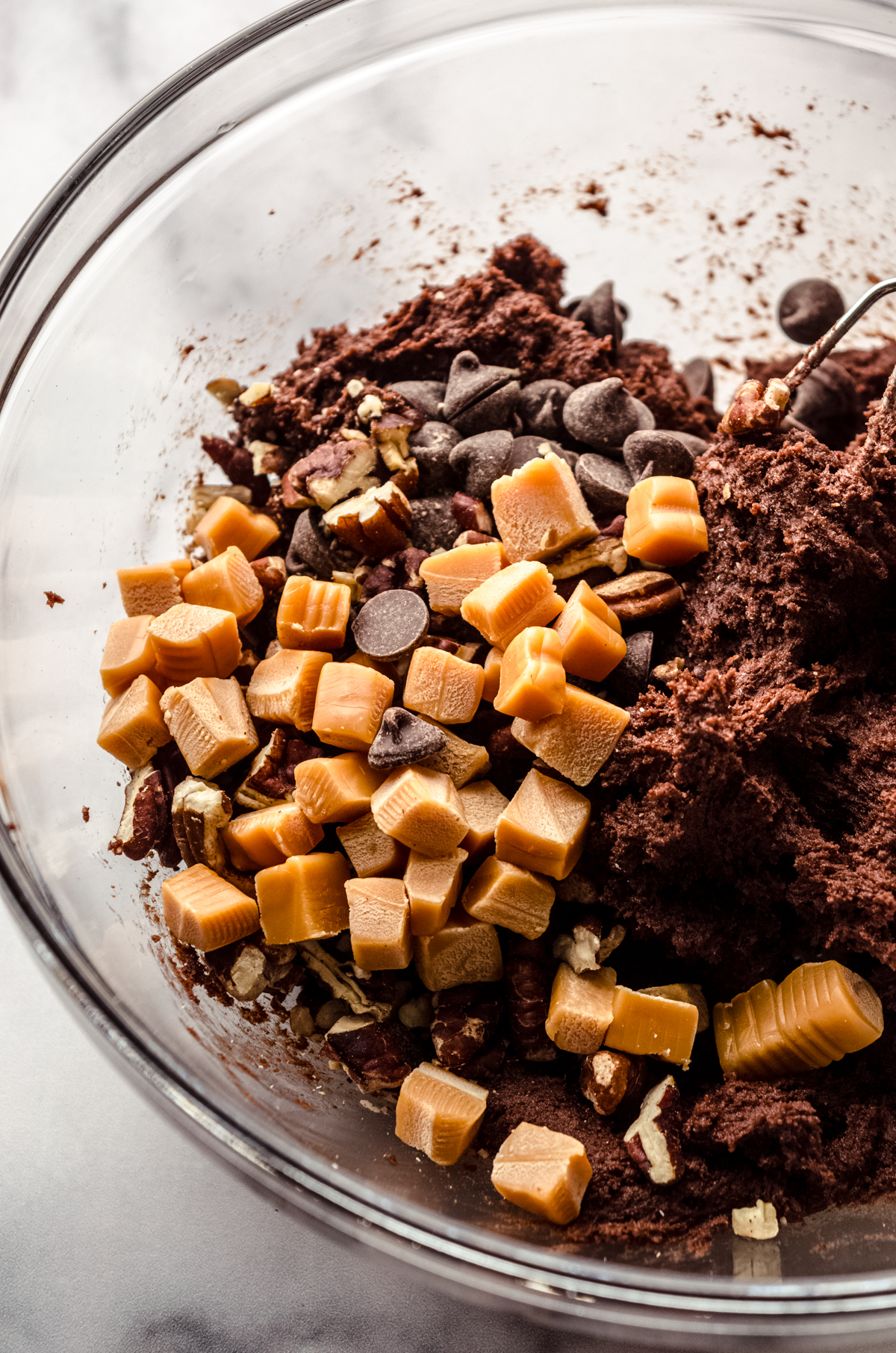 Chocolate turtle cookie dough in a bowl.