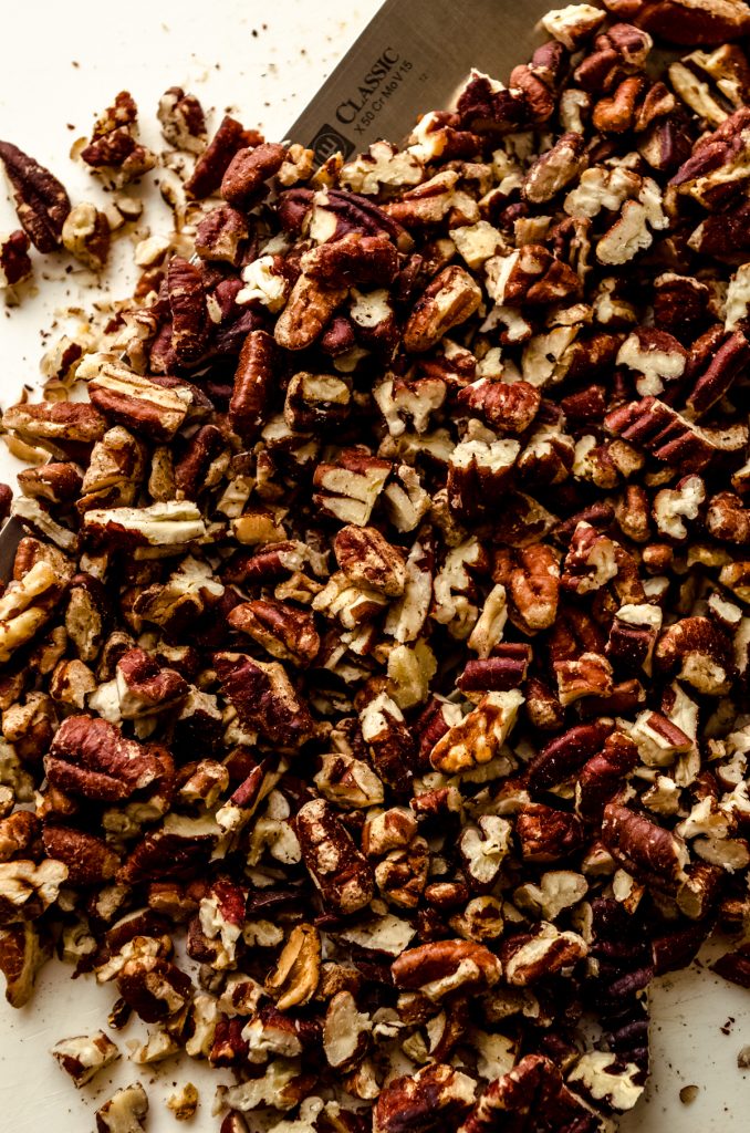 Toasted pecans on a cutting board.