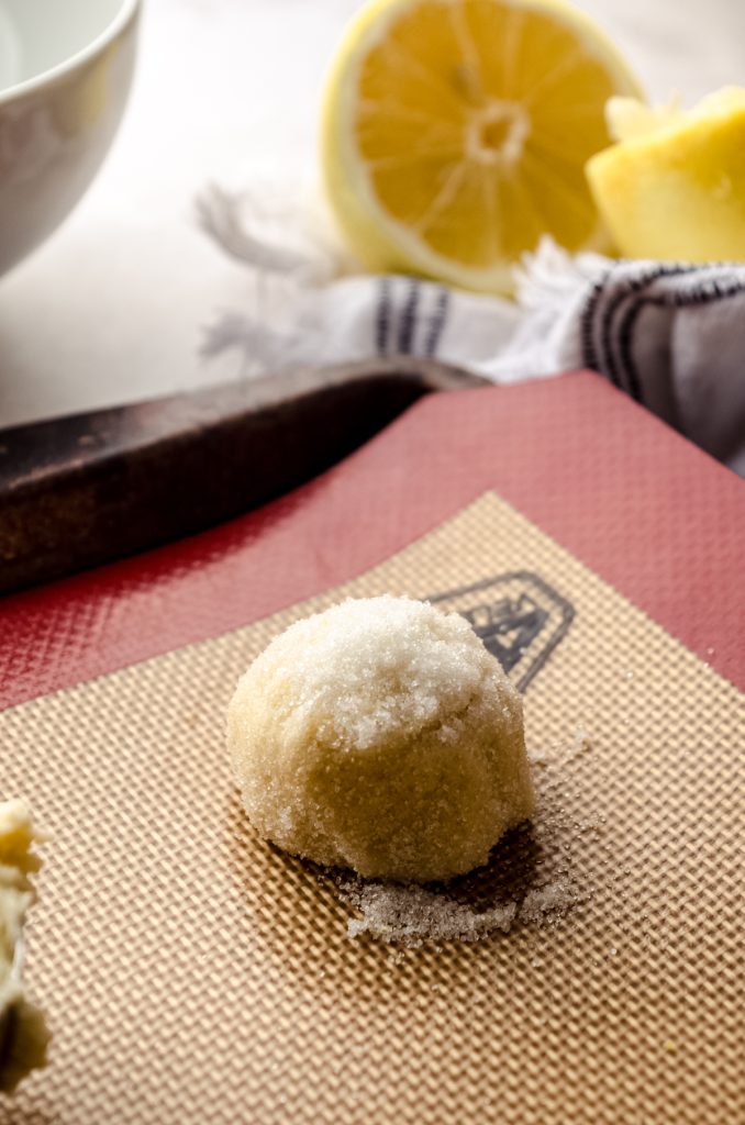 A ball of lemon sugar cookie dough on a baking sheet.