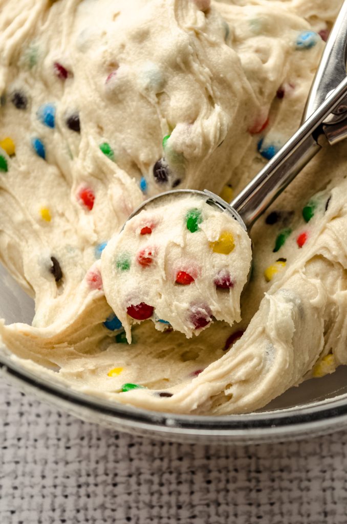 A scoop in a bowl of m&m sugar cookie dough.