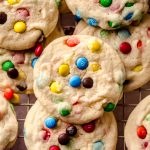 Aerial photo of m&m cookies on a cooling rack.