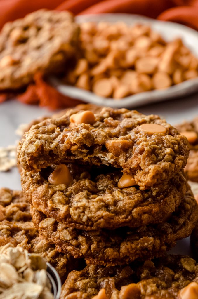 A pile of oatmeal scotchies with a bite taken out of the one on the top.