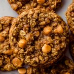 Aerial photo of oatmeal scotchies on a surface with oats scattered around,