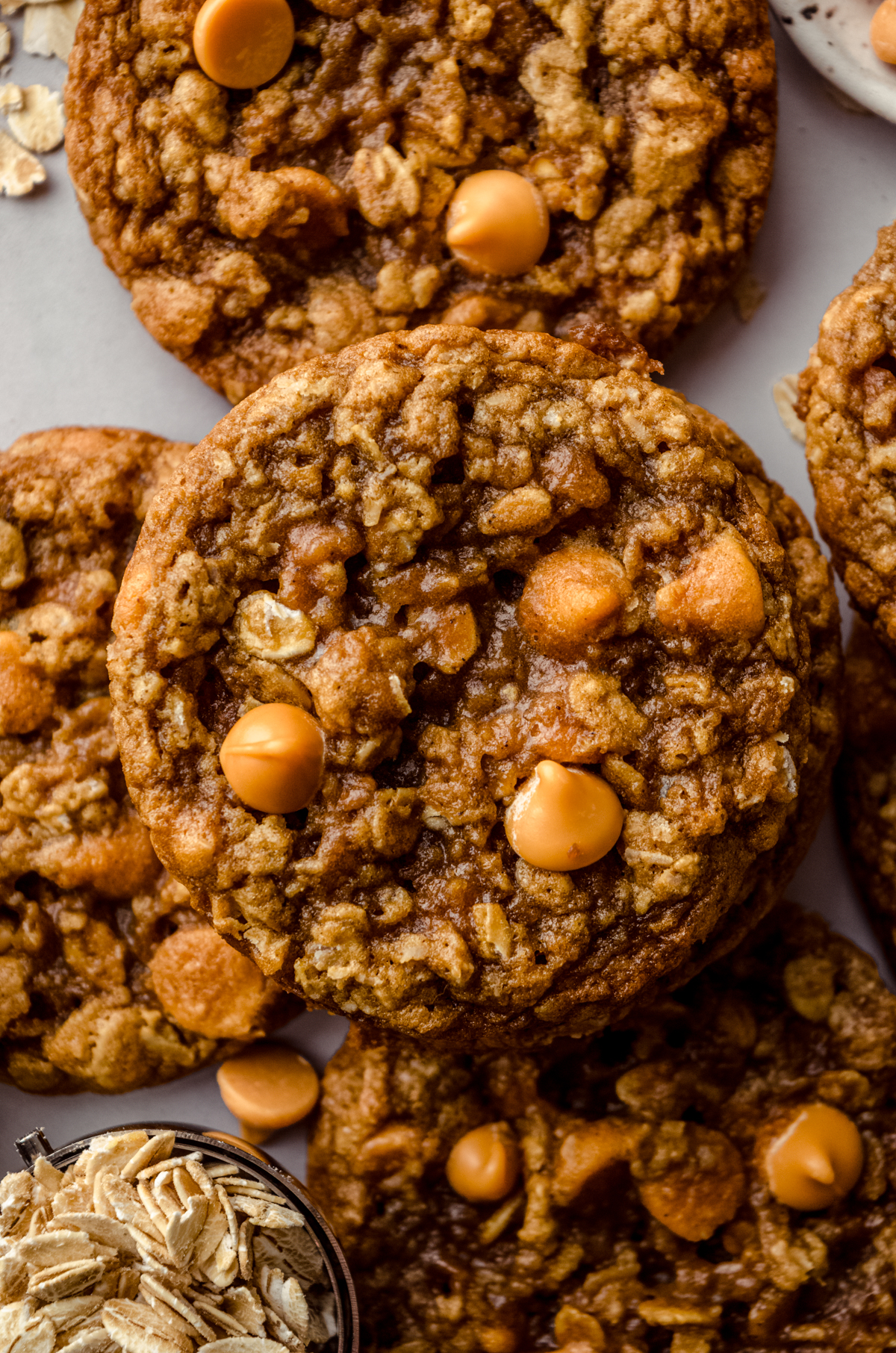 Aerial photo of oatmeal scotchies on a surface with oats scattered around,