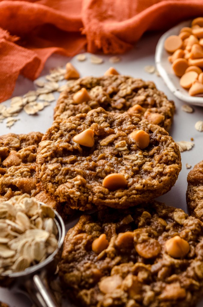 Oatmeal scotchies on a surface with oats scattered around,