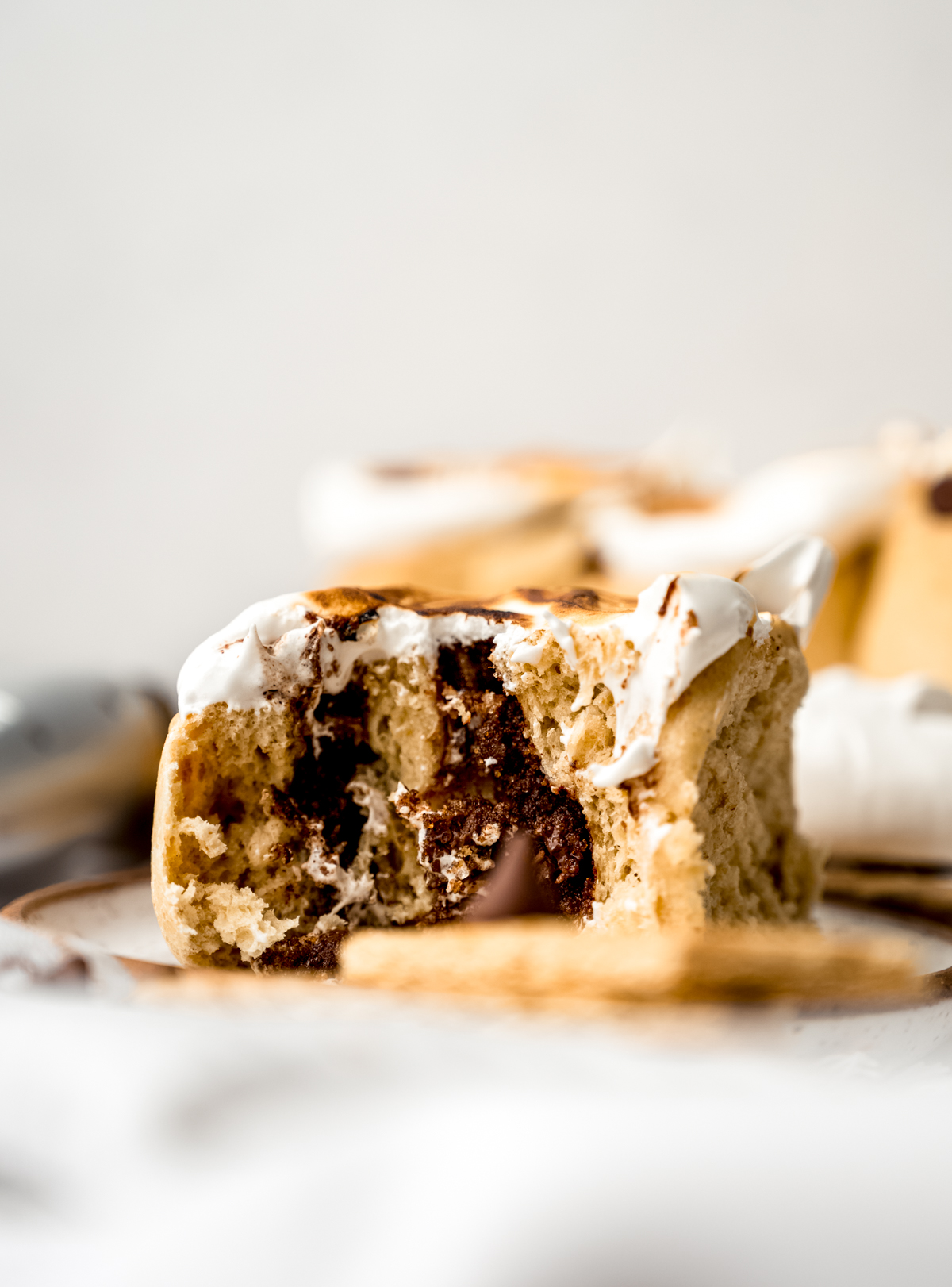 A s'mores cinnamon roll on a plate.