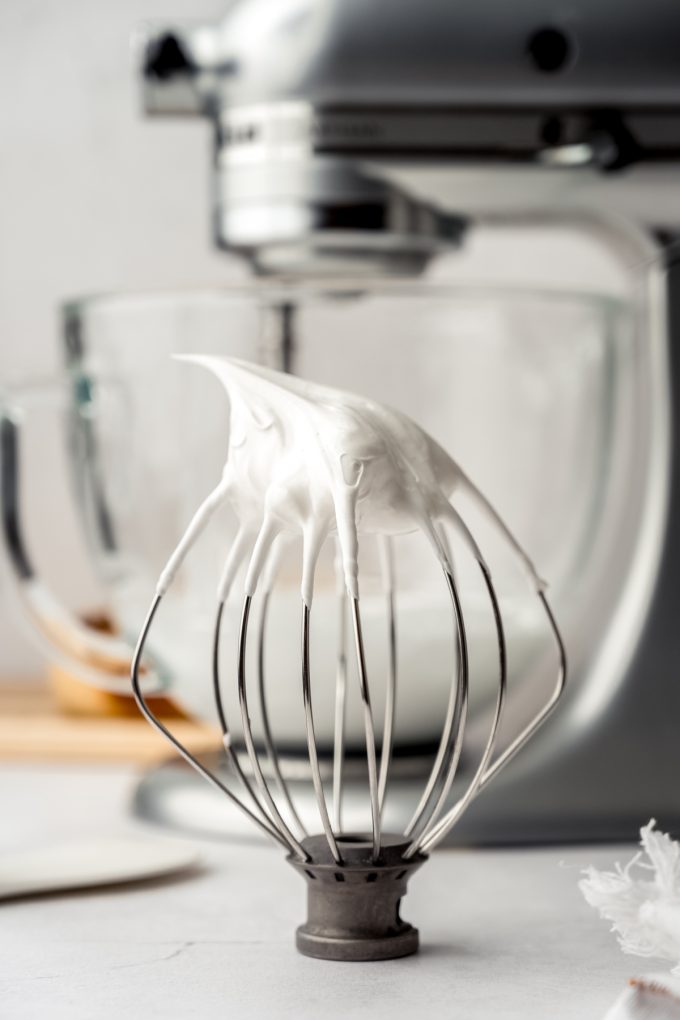 A whisk attachment for a stand mixer with marshmallow meringue on it.