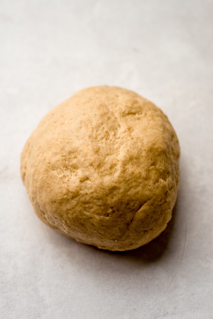 A ball of s'mores cinnamon roll dough on a surface.