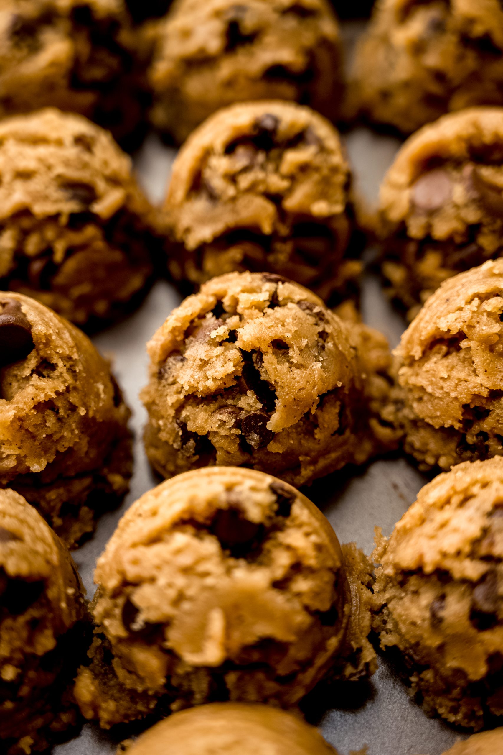 Balls of fall spiced chocolate chip cookie dough on a baking sheet.