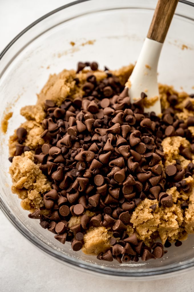 A bowl of fall spiced chocolate chip cookie dough with a spatula in it.