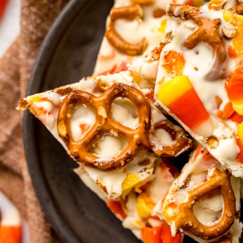 Aerial photo of candy corn bark with pretzels on a plate.