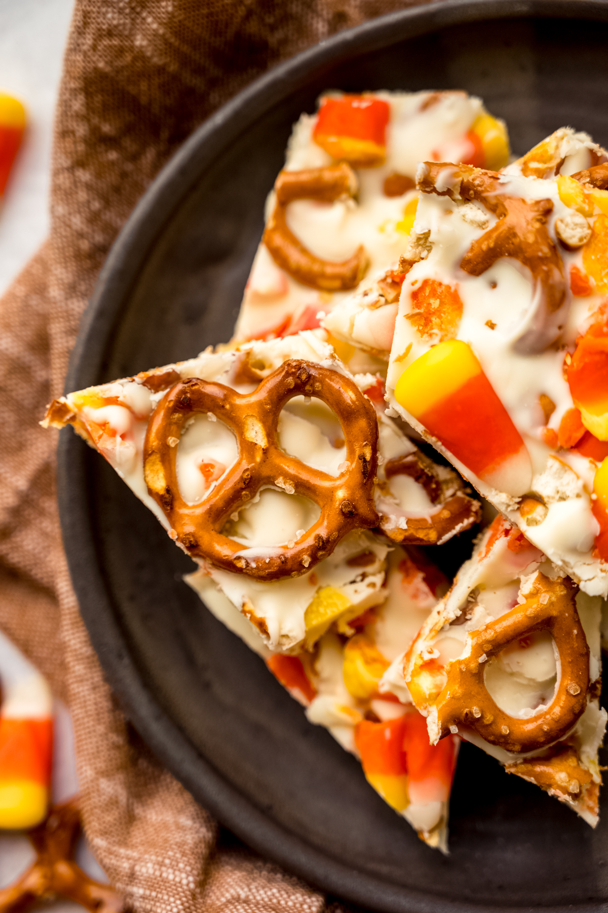 Aerial photo of candy corn bark with pretzels on a plate.