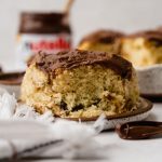 A Nutella roll on a plate with a jar of Nutella in the background.