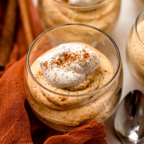 A dessert cup with pumpkin mousse in it.
