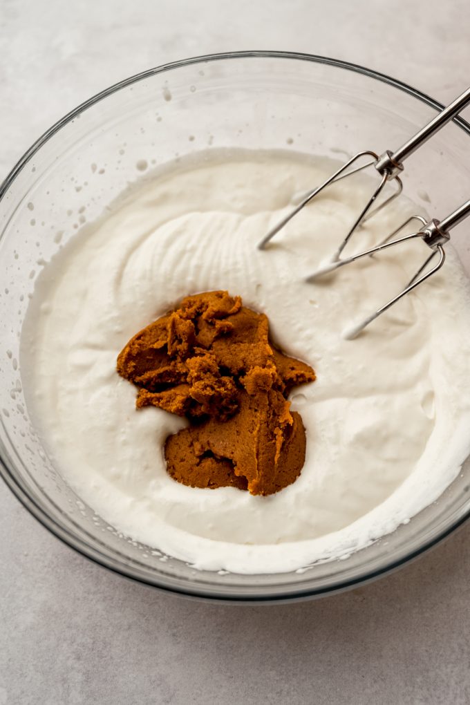 Pumpkin puree in a bowl of whipped cream to make pumpkin mousse.
