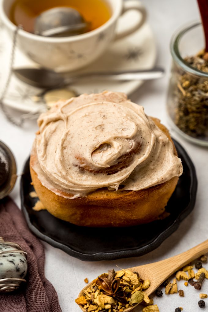A chai cinnamon roll sitting on a plate.