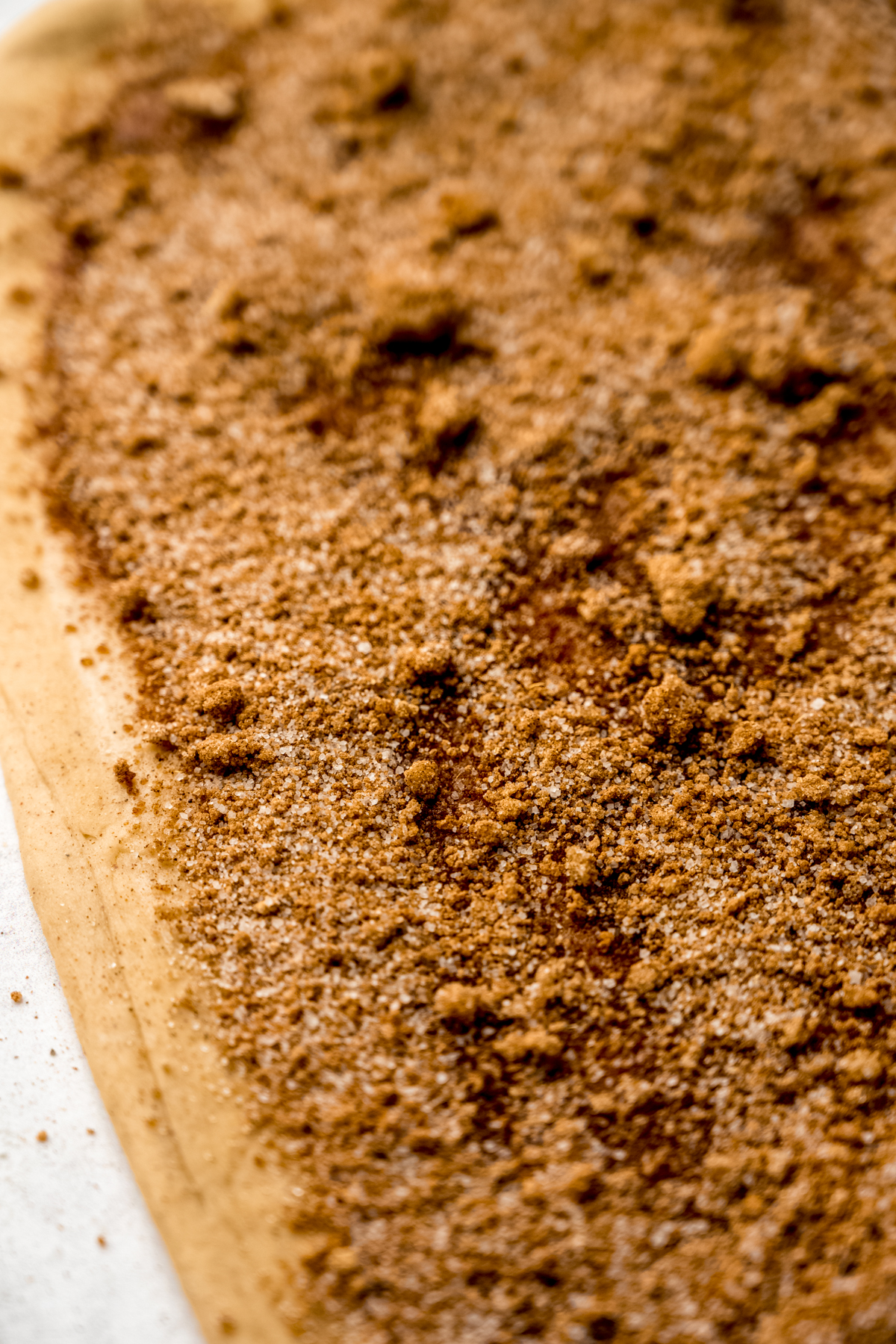 A closeup photo of a rectangle of chai cinnamon roll dough with filling.