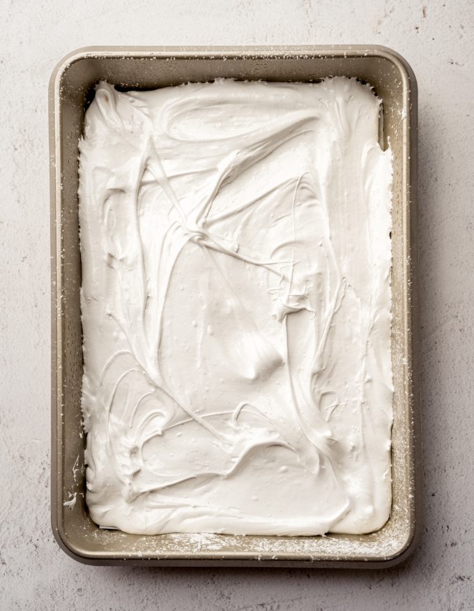 A baking dish with homemade marshmallow mixture in it.