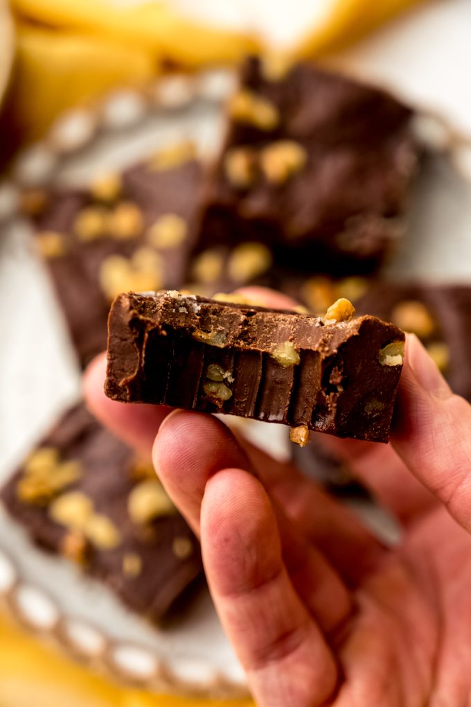 Someone is holding a piece of microwave fudge with a bite taken out of it.