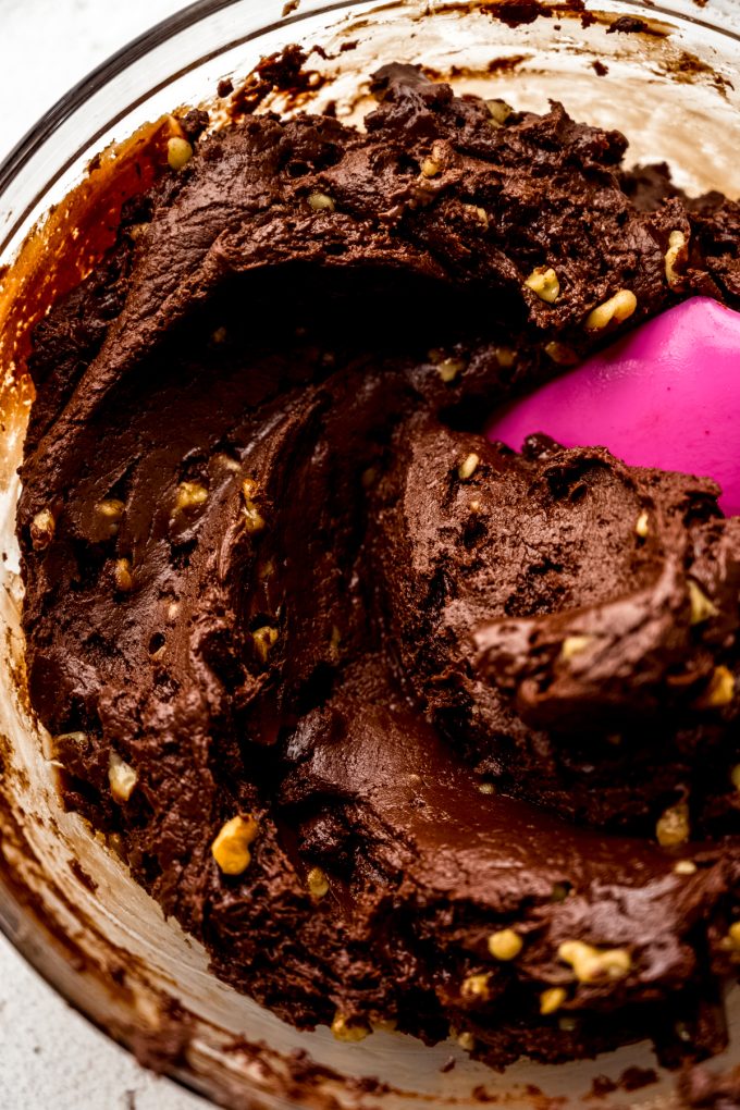 Microwave fudge batter in a bowl with a spatula.