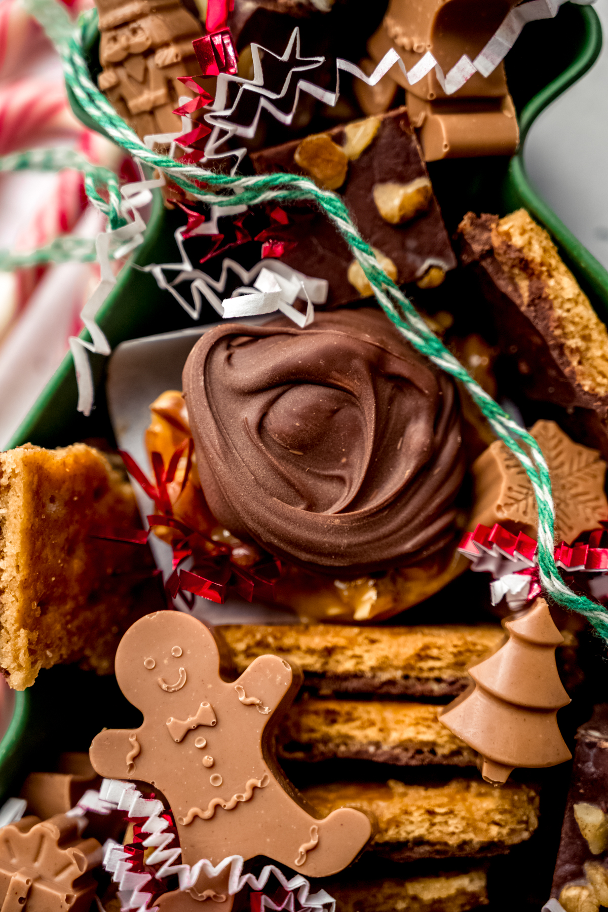Aerial photo of a Christmas tree shaped container with various holiday candies in it.