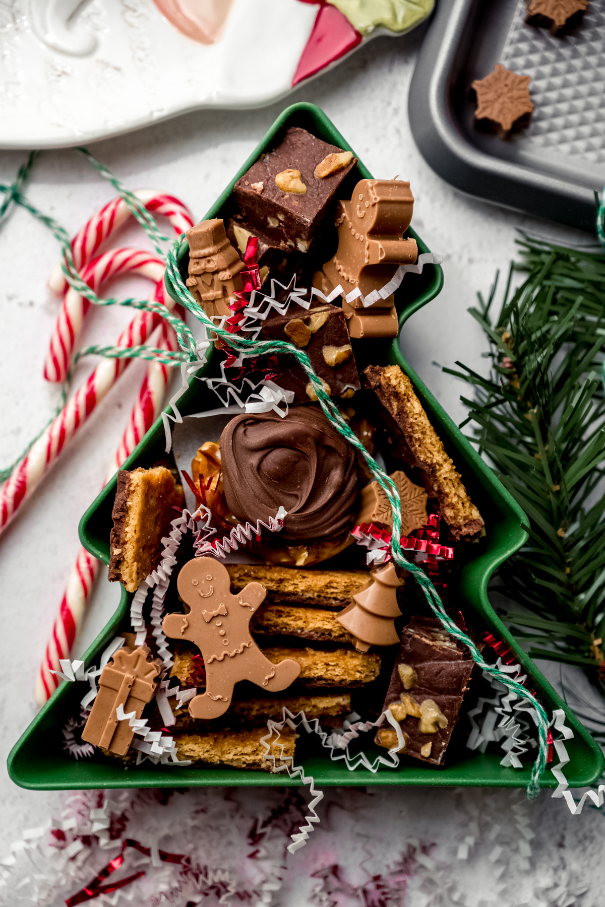 Aerial photo of a Christmas tree shaped container with various holiday candies in it.