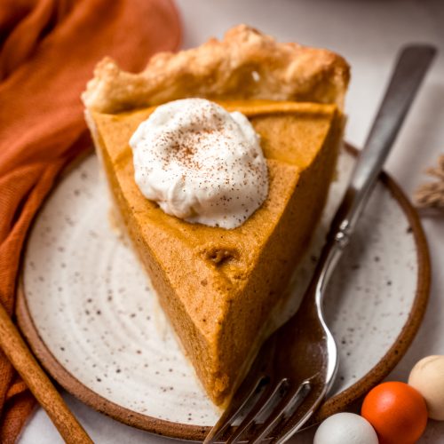 A slice of pumpkin chiffon pie on a plate with a fork.