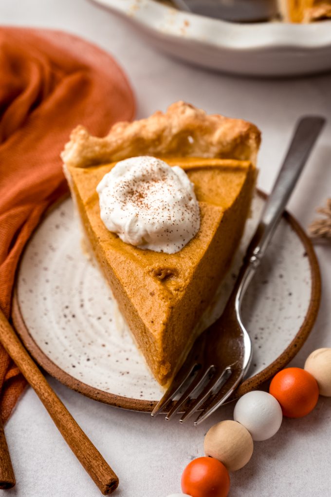A slice of pumpkin chiffon pie on a plate with a fork.
