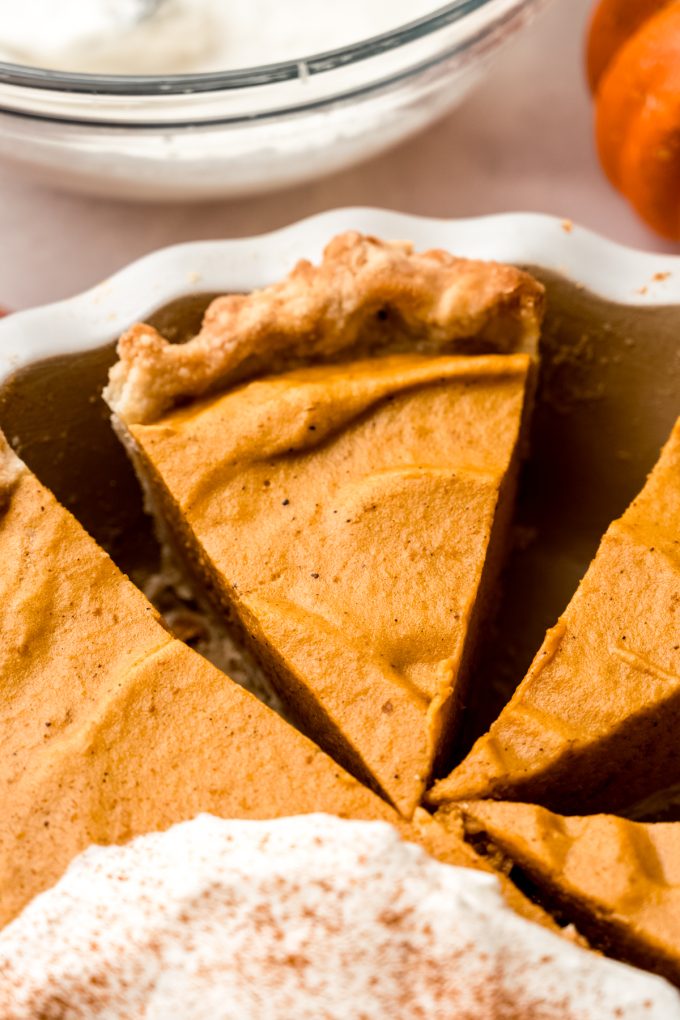 Pumpkin chiffon pie in a pie plate and it has been sliced.