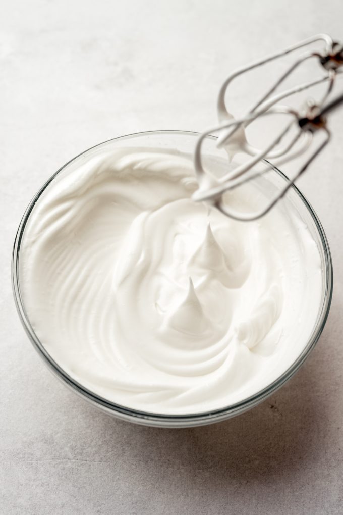 A bowl of whipped egg whites with stiff peaks.