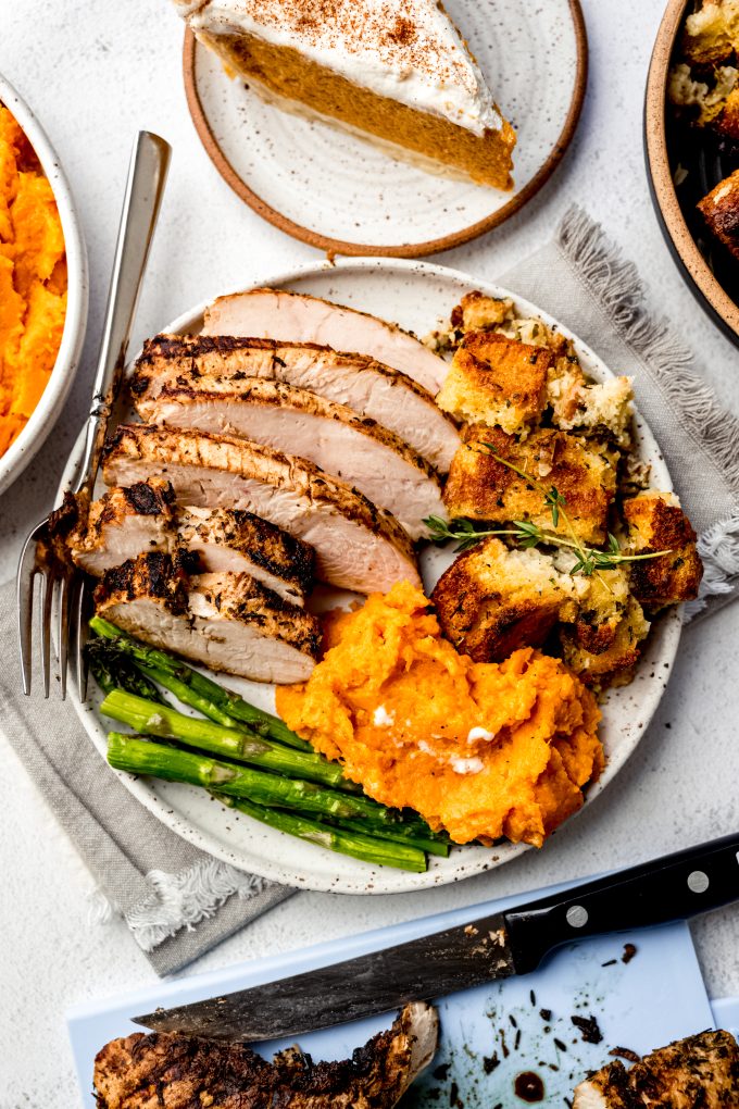 Aerial photo of turkey tenderloin, asparagus, cornbread stuffing, and mashed sweet potatoes.