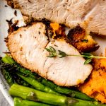 An aerial photo of a plate of turkey tenderloin, asparagus, and sweet potatoes.