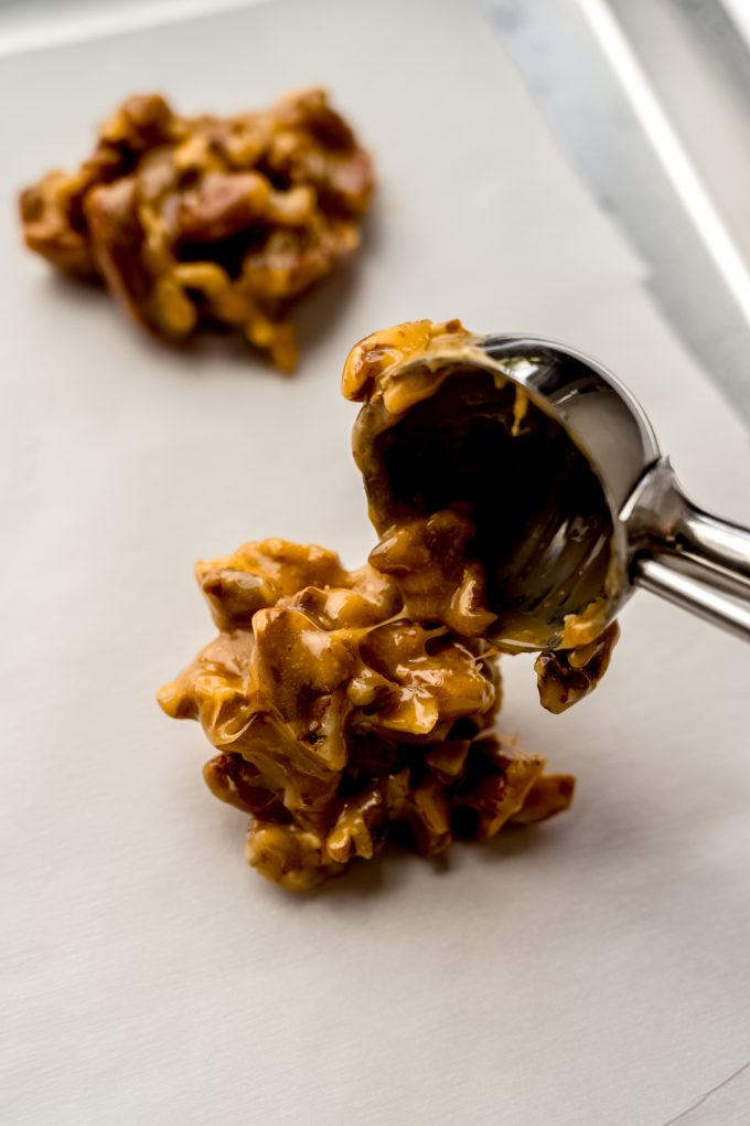 Someone is using a cookie scoop to portion out turtle candy.